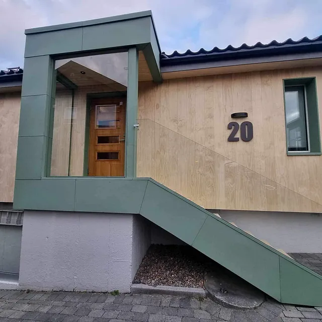 Husinngang med trebekledning og grønnlakkerte blikkdetaljer